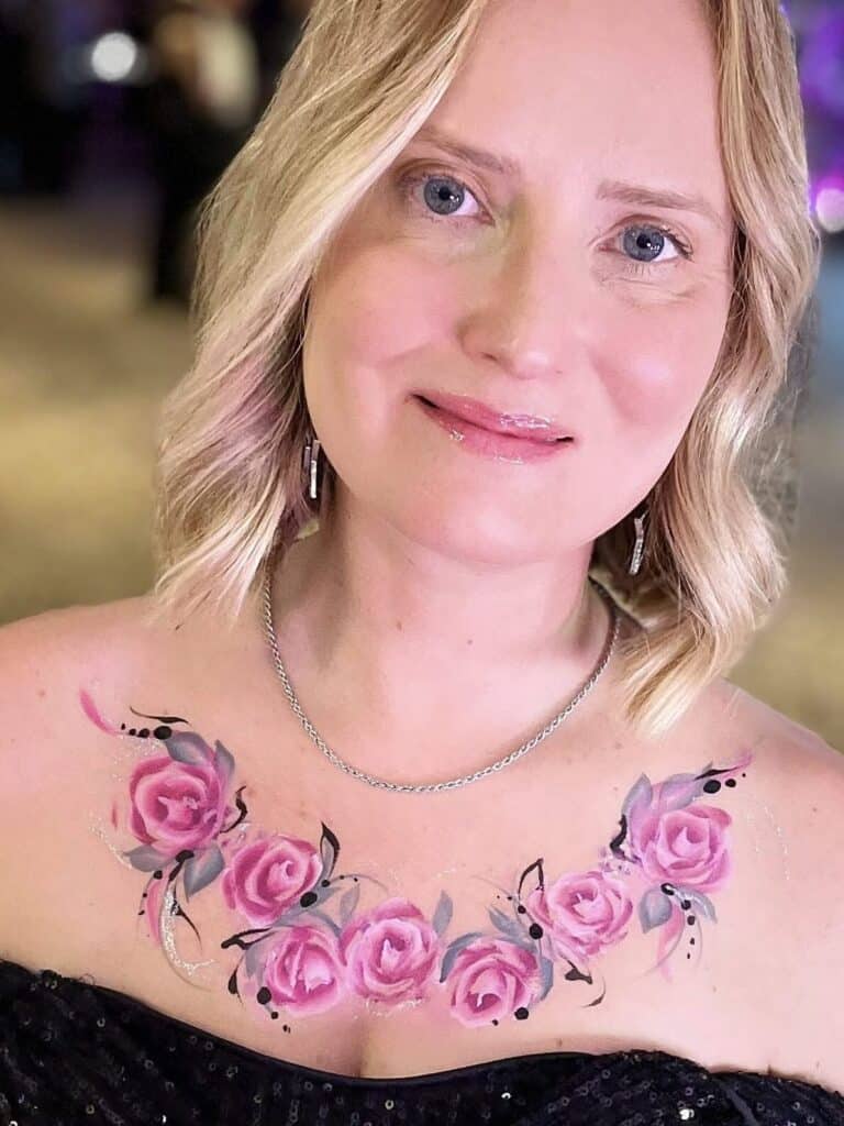 A lady with a chest body paint of pink roses, with glitter, at a corporate event